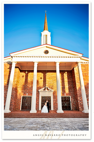 Outdoor photo of church with bride and groom.