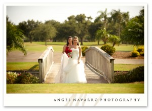 A beautiful bride steps over a bridge.