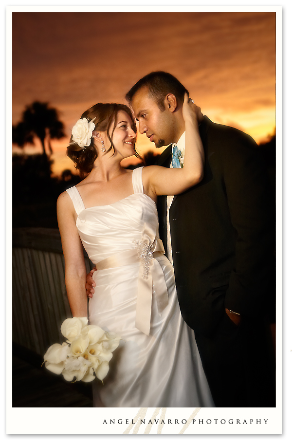 A wedding portrait of the bride and her groom atop a wooden bridge.