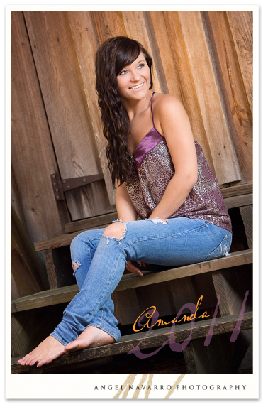 A high senior gal posed in a barn setting setting for her senior picture.
