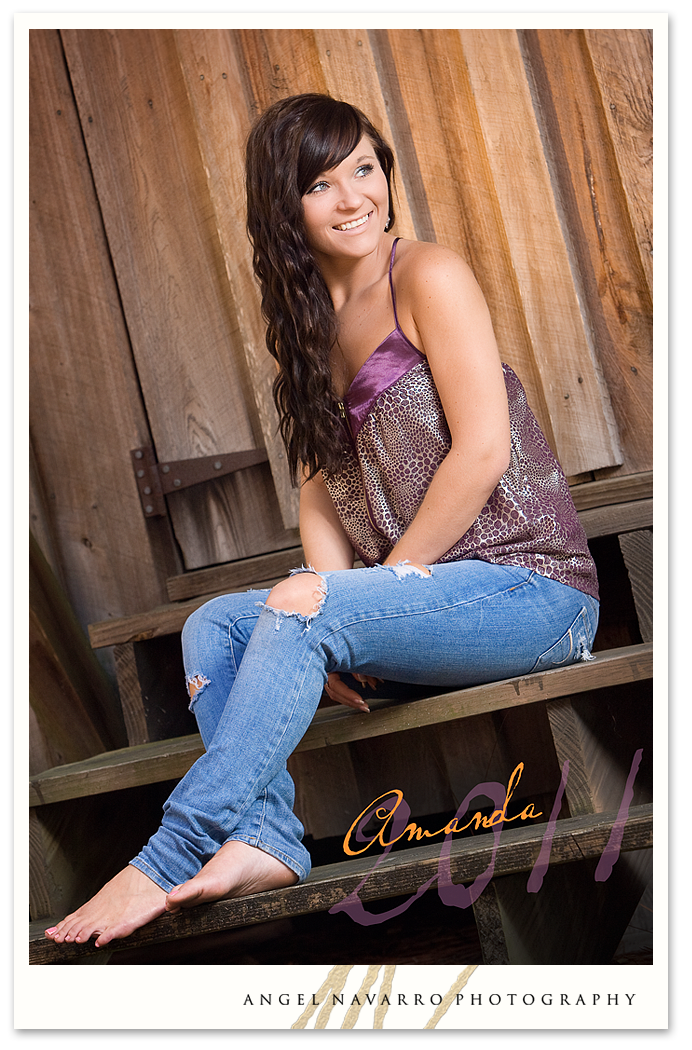 A high senior gal posed in a barn setting setting for her senior picture.