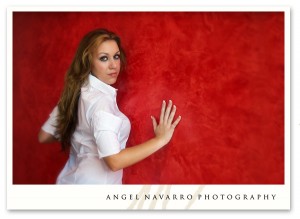 The very pretty Andrea leans up against a red wall for a stunning candid.