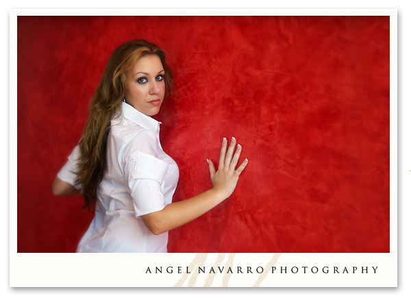 The very pretty Andrea leans up against a red wall for a stunning candid.