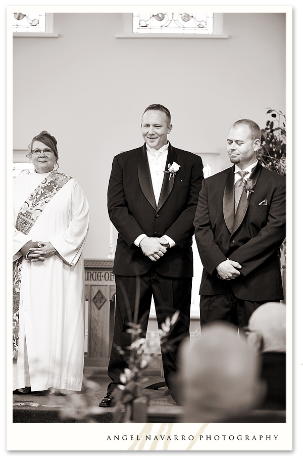 Groom looks upon his bride with joy as she walks towards him on the altar.