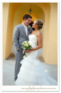 A portrait of the bride and groom in m arched hallway.