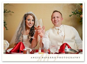 Bride and groom hold toasting glasses for a photograph.